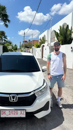 A customer with our white Honda Brio on a quiet lane