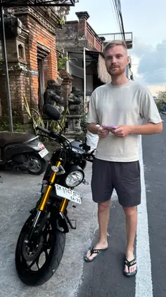A customer collecting a Yamaha XSR 155 by a temple wall
