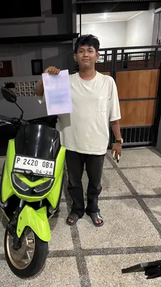 A customer with the signed rental agreement next to a green scooter
