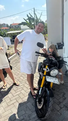 A family collecting a Yamaha XSR 155 outside their guesthouse